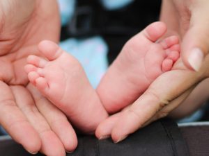 赤ちゃんの足と母親の手
